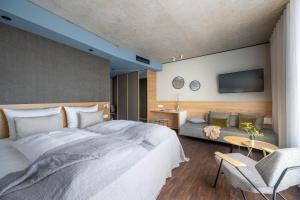 Hotel Maier في فريدريشسهافن: غرفة نوم بسرير كبير وأريكة
