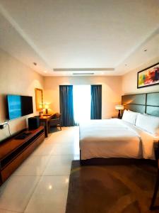 een hotelkamer met een groot bed en een televisie bij Oakwood Residence Kapil Hyderabad in Hyderabad