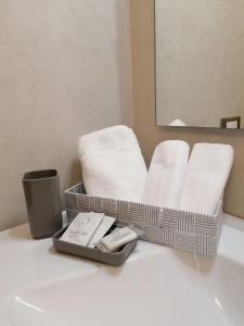 ドッソブオノにあるHotel Europaのバスルーム(白いタオル、タオルのトレイ付)