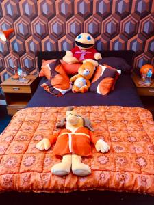 two stuffed animals are laying on a bed at The Retro Retreat with free parking in Hastings