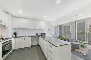 a kitchen with white cabinets and a large window at WARRICK FRAM 3 BEDS APT FREE PARKING WALK TO WESTFIELD CLOSE TO HOSPITAL NWF003 in Warwick Farm