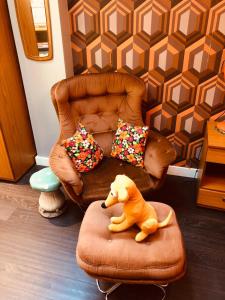 a toy dog sitting on a ottoman in front of a chair at The Retro Retreat with free parking in Hastings