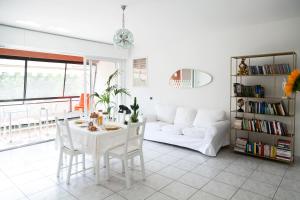 un soggiorno con tavolo bianco e divano bianco di Maison da Paola a Basiglio