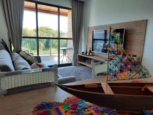 uma sala de estar com um barco de madeira no chão em Barra de São Miguel Quarto e sala ILOA 104S na Barra de São Miguel