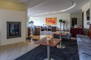 a living room with a couch and a table at Hotel am Wasserfall in Lingen