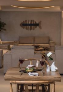 a wooden table with two glasses of red wine at GARDELLI RESORT in Laganas