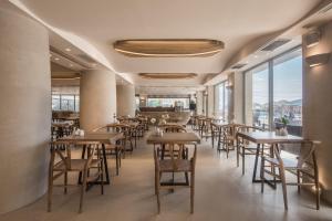 a dining room with tables and chairs and windows at GARDELLI RESORT in Laganas +37 photos