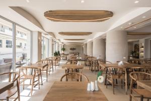 a dining room with wooden tables and chairs at GARDELLI RESORT in Laganas