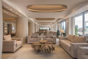 a lobby with couches and a table and windows at GARDELLI RESORT in Laganas
