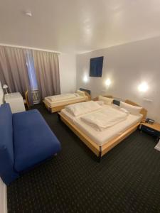 a hotel room with two beds and a blue chair at Luise City - An der Philharmonie in Essen