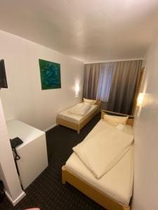 a hotel room with two beds and a window at Luise City - An der Philharmonie in Essen +7 photos