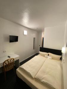 1 dormitorio con 1 cama y escritorio con TV en Luise City - An der Philharmonie, en Essen