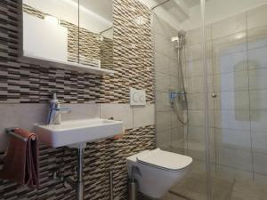 a bathroom with a sink and a toilet and a shower at Apartmani Polanščak in Krapinske Toplice +29 photos