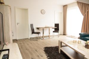 sala de estar con mesa y sillas en Appartementhaus Elm Immobilien en Königslutter am Elm