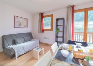 a living room with a couch and a table at Les Terrasses du Soleil d'Or By Infini Mountain in Les Orres