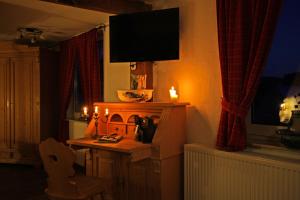 sala de estar con TV y mesa con chimenea en Hotel Restaurant Lindenhof, en Bad Laasphe