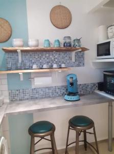 eine Küchentheke mit zwei Hockern und einem blauen Mixer in der Unterkunft Appart Sophyann in Saint-Gilles-les-Bains