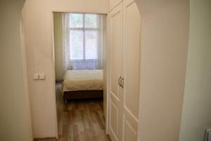 mały pokój z łóżkiem i oknem w obiekcie Apartman Sylva na Staré Louce 42 w Karlowych Warach