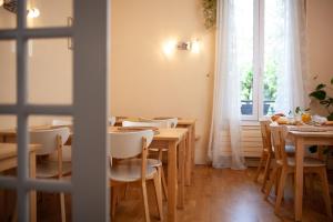 una sala da pranzo con tavoli e sedie in legno e una finestra di Hôtel du Parc a Choisy-le-Roi