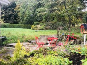 インバネスにあるHome Comforts in Peaceful 2 Acresの庭園内の赤いテーブルと椅子