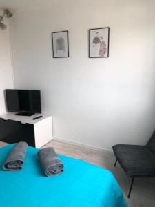 - une chambre avec un lit, une télévision et une chaise dans l'établissement Monplaisir, à Toulouse