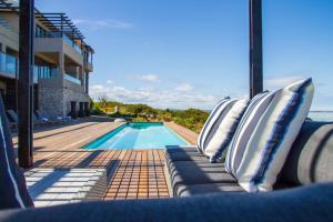 a view of a swimming pool with pillows on a couch at The Shark Bay Boutique Hotel & Spa in Langebaan