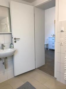 a bathroom with a door leading to a sink at Ferienwohnung I in Papenburg +14 photos