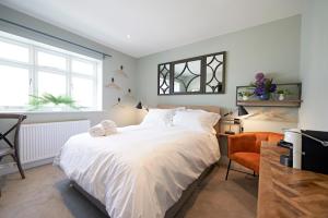 1 dormitorio con 1 cama blanca grande y 1 silla en Valentino s Restaurant with Rooms, en Ripon