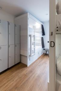 a large room with white cabinets and a bed at Airhostel Barcelona Airport 24h in El Prat de Llobregat