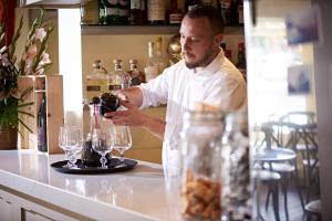 Ein Mann, der Wein in ein Weinglas gießt. in der Unterkunft Valentino s Restaurant with Rooms in Ripon