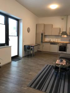 a living room with a table and a kitchen at Ferienwohnung I in Papenburg