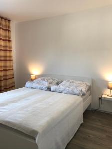 a bedroom with a bed with two lamps on the wall at Ferienwohnung I in Papenburg