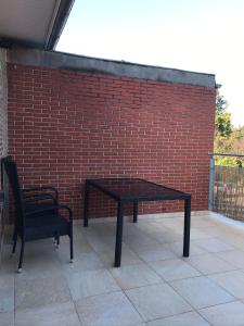a black table and a chair on a brick wall at Ferienwohnung I in Papenburg