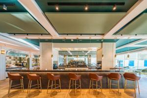 a bar in the lobby of a restaurant with stools at Catalonia Donosti in Donostia-San Sebastián