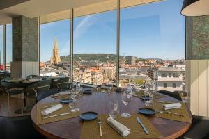 a table in a restaurant with a view of a city at Catalonia Donosti in Donostia-San Sebastián