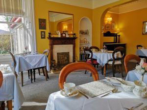 a dining room with tables and a fireplace at Annslea Guest House in Pitlochry