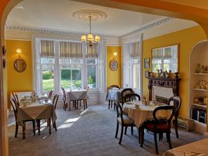 comedor con mesas y sillas y chimenea en Annslea Guest House, en Pitlochry
