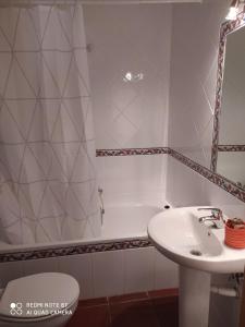 een badkamer met een wastafel, een bad en een toilet bij Casa Puerto in Noguera de Albarracin