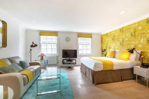 - un salon avec un lit et un canapé dans l'établissement Marylebone - Wyndham Street by Viridian Apartments, à Londres