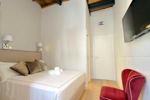 een slaapkamer met een wit bed en een rode stoel bij Monti Panisperna suites in Rome