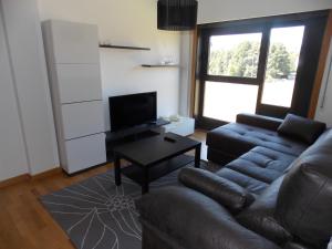 a living room with a couch and a table at Piso Rosalía de Castro in Allariz