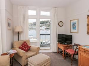 Una sala de estar con una gran ventana y un televisor. en 2 York House, en Dartmouth