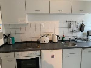 a kitchen with a sink and a counter top at City Studio Apartment in Bremerhaven +1 photo