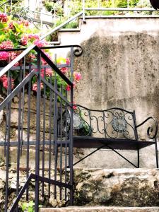a metal bench next to a staircase with flowers at Hiša Liza in Kobarid