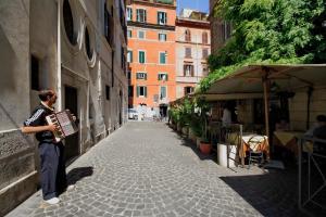 een man die over een straat loopt met een accordeon bij Monti Panisperna suites in Rome