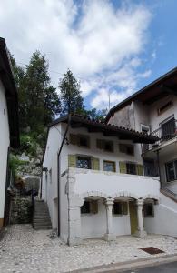 a white building with an archway on the side of it at Hiša Liza in Kobarid