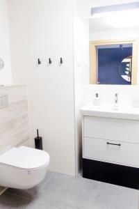 ein weißes Bad mit einem WC und einem Waschbecken in der Unterkunft Apartament z widokiem na morze SEASIDE 208 AL-DOM in Kołobrzeg