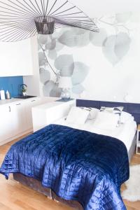 ein Schlafzimmer mit einem Bett mit einer blauen Decke in der Unterkunft Apartament z widokiem na morze SEASIDE 208 AL-DOM in Kołobrzeg