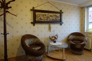 sala de estar con 2 sillas y mesa de cristal en White House Apartments, en Odessa
