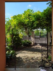 Une porte ouverte s'ouvre sur un patio arboré. dans l'établissement Valle Fiorita, à Castro dei Volsci